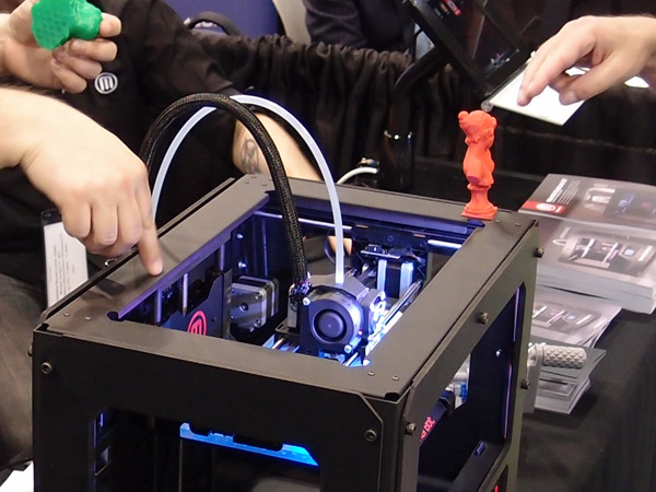 Pohled do útrob designově vyladěného MakerBot Replicatoru 2. To modré světlo nemá žádný praktický význam, prostě je "cool". Barva se dá změnit výměnou osvětlovacích diod. Foto: Jan Homola